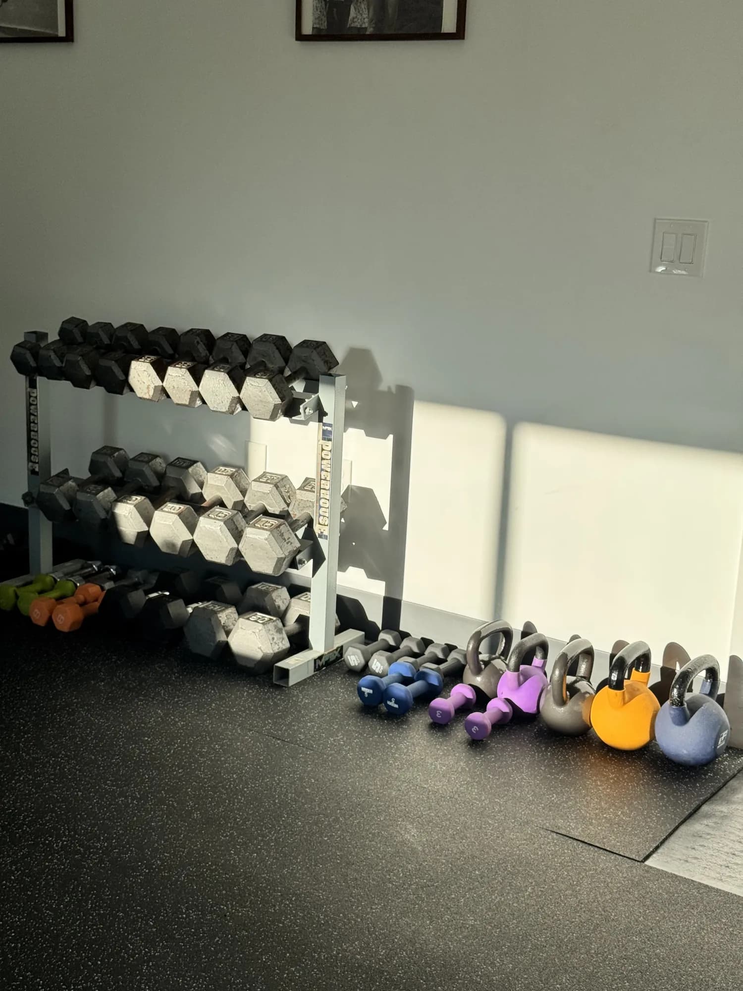 Dumbbells and kettlebells along the wall in the new training studio.
